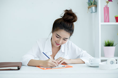 Person writing on paper to enhance skills